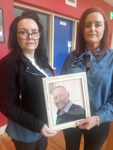 Tony Rogers's daughters Eleanor and Gillian (l-r) with a photo of their late father 