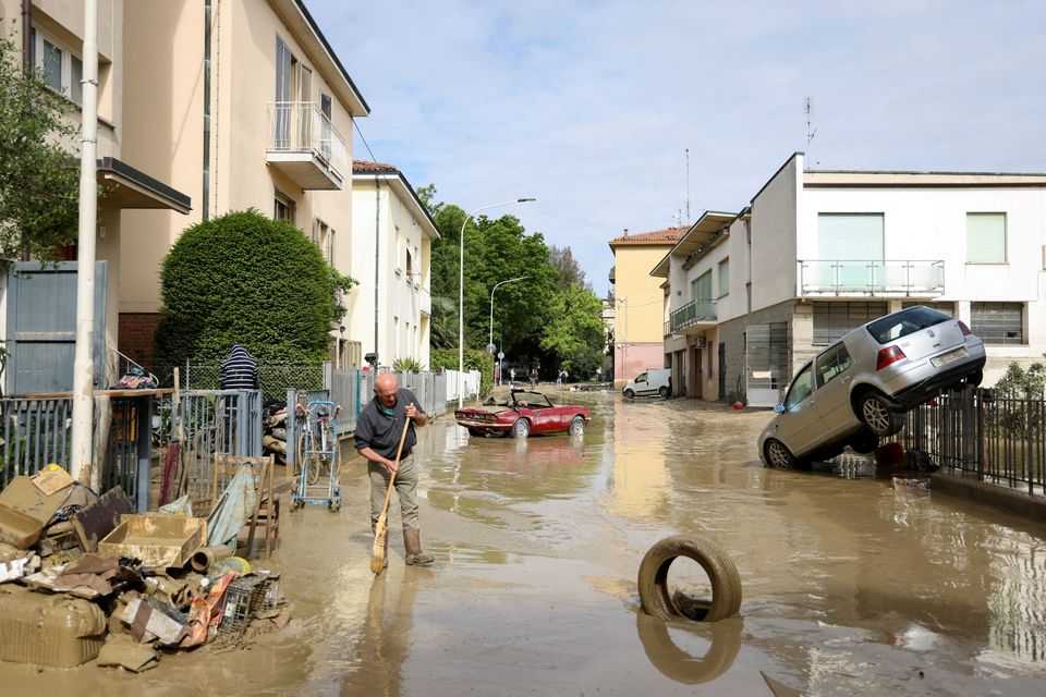 A resident removes mud and debris yesterday after heavy rain flooded Italy’s Emilia Romagna region. Photo: Claudia Greco/Reuters