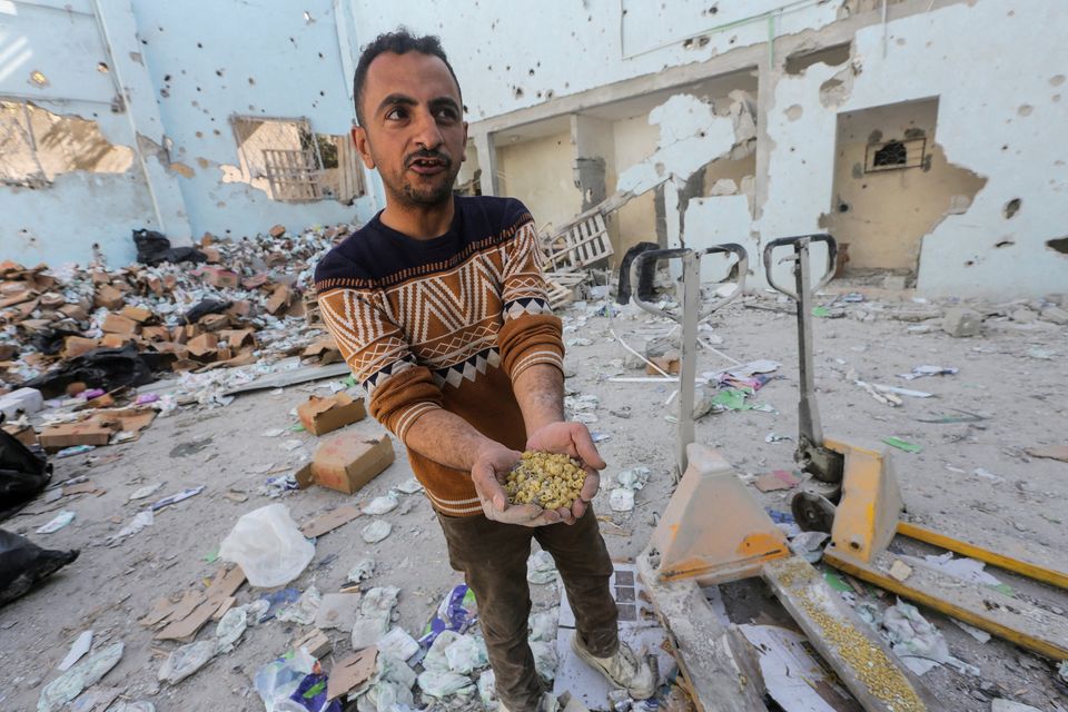 A Palestinian holds uncooked pasta at the site of an Israeli strike on an aid warehouse in Al-Nuseirat refugee camp in the central Gaza Strip. Photo: Reuters
