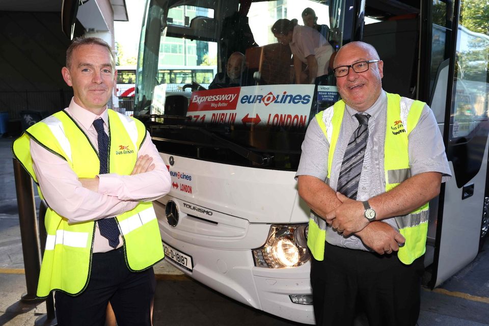 Bus Éireann employees and Mr Popescu in the bus' driver's seat checking passengers in.