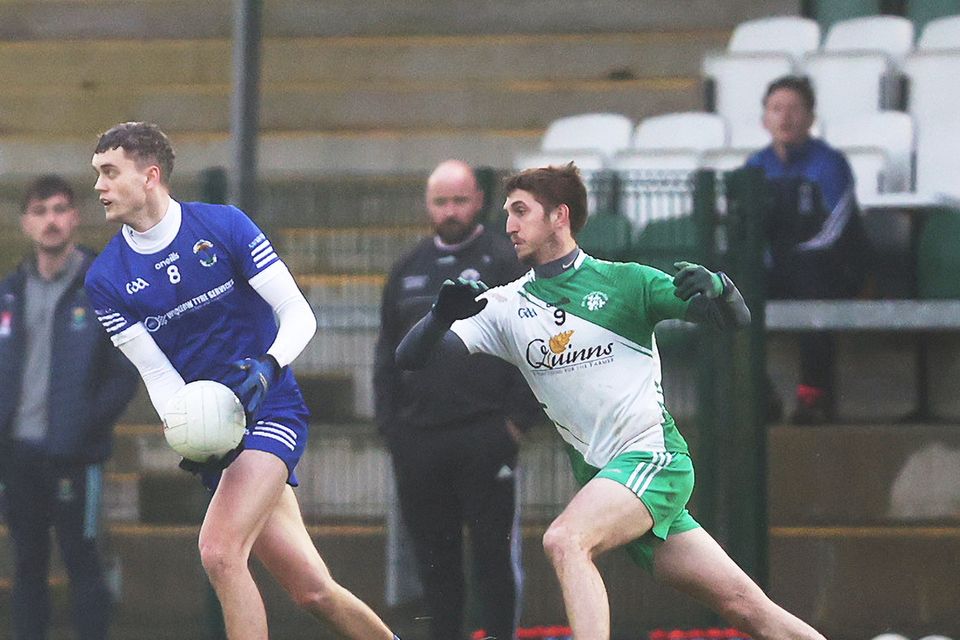 Ronan Murray of St. Pat's prepares to pass as Pat Burke of Baltinglass- gives chase. 
