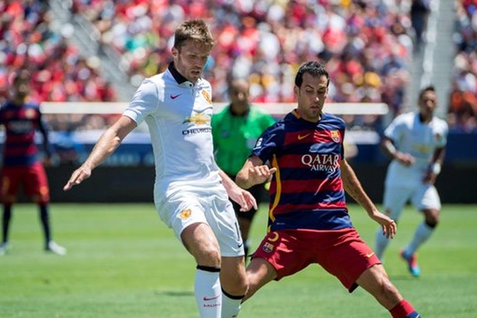 Michael Carrick (L) of Manchester United protects the ball from Sergio Busquets (R) of FC Barcelona during an International Champions Cup match at Levi's Stadium in Santa Clara, California on July 25, 2015