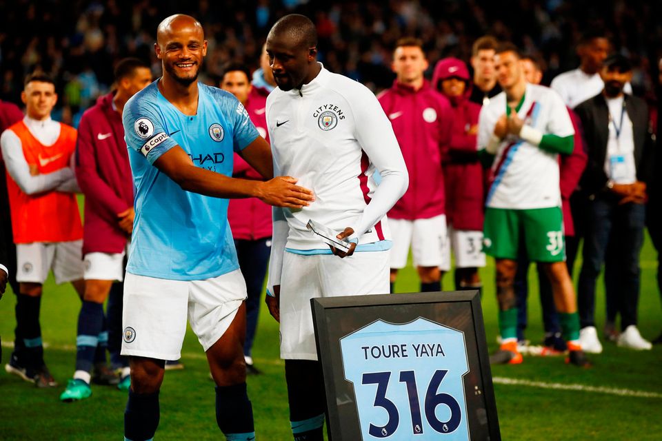 Manchester City's Yaya Toure is presented with a shirt as Vincent Kompany looks on during a ceremony after the match