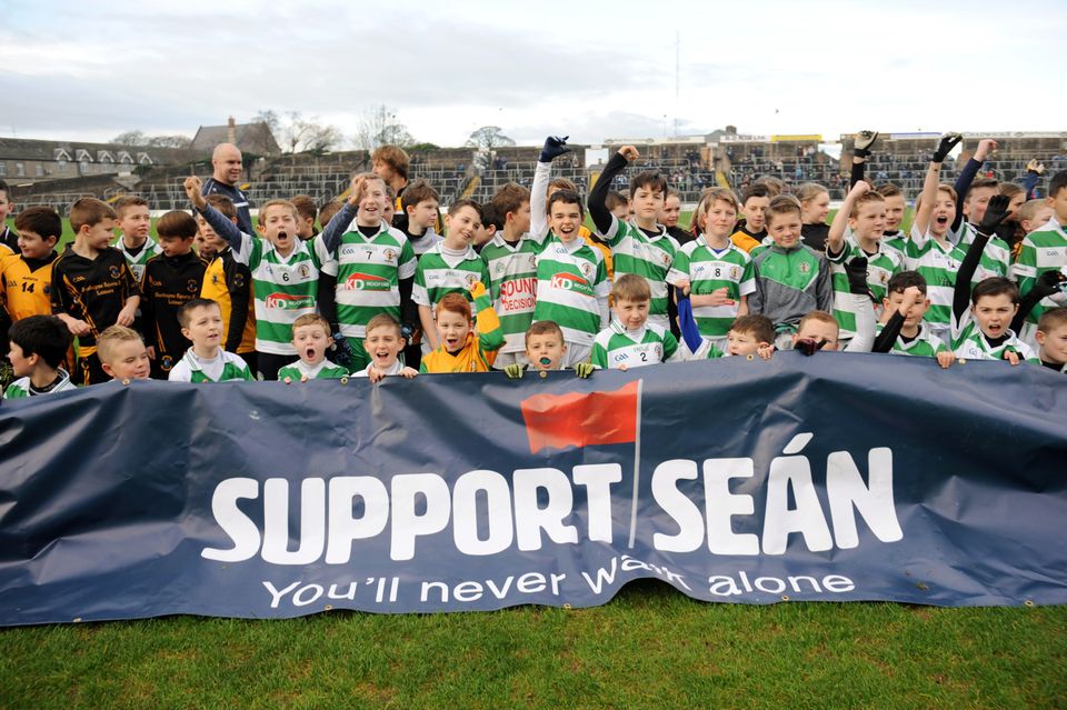 Young GAA players from St. Peter's, Dunboyne, and Round Towers, Clondalkin, with a banner before the game