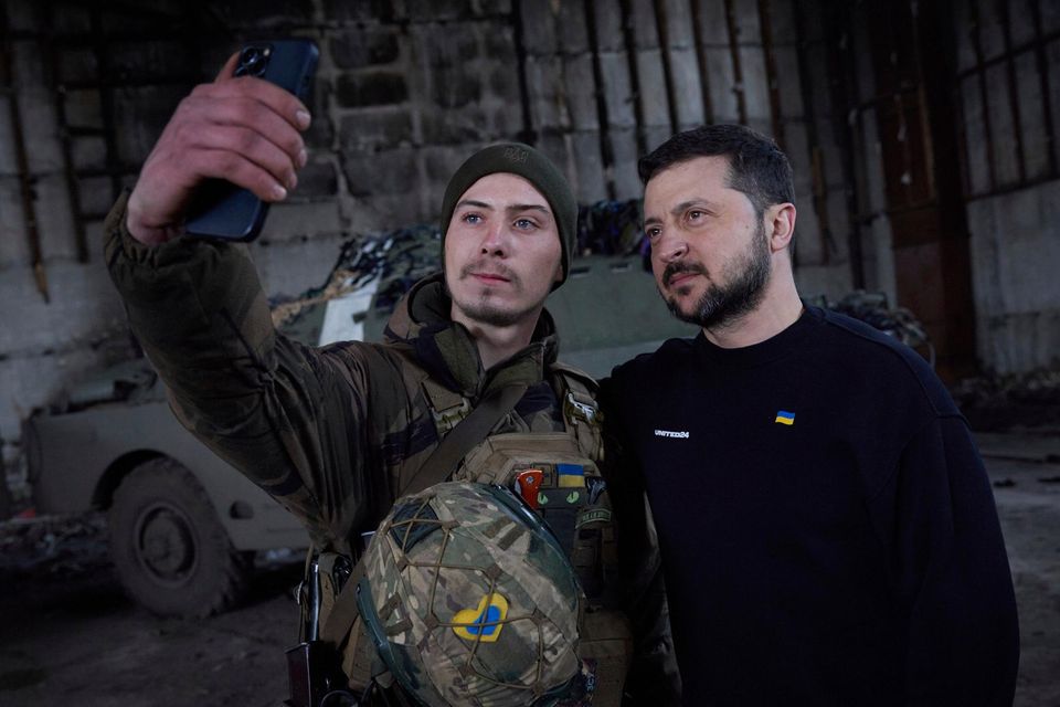 Volodymyr Zelensky poses with a Ukrainian service member at a position near a frontline. Photo: Reuters