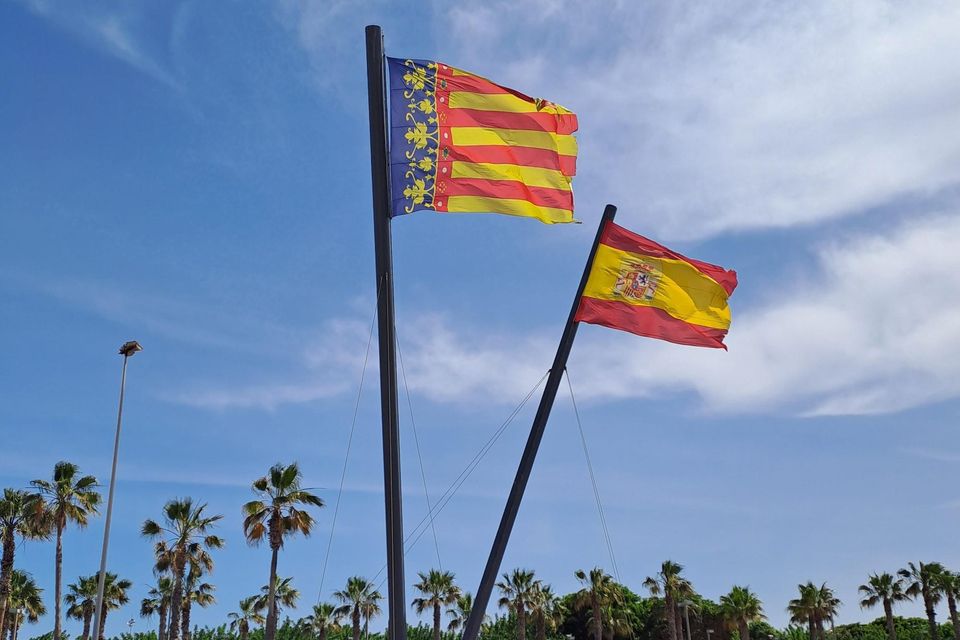 The Valencian flag flies alongside the Spanish flag on the beach in Valencia.
