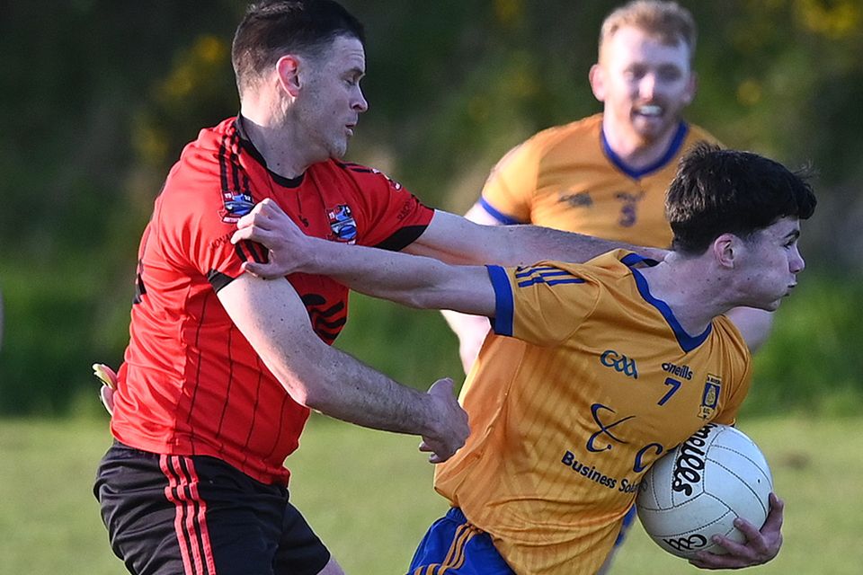 Mattock Rangers' Darren Henry is held off by Daniel Craven of St Mochta's during Saturday night's clash in Collon. Picture: Colin Bell