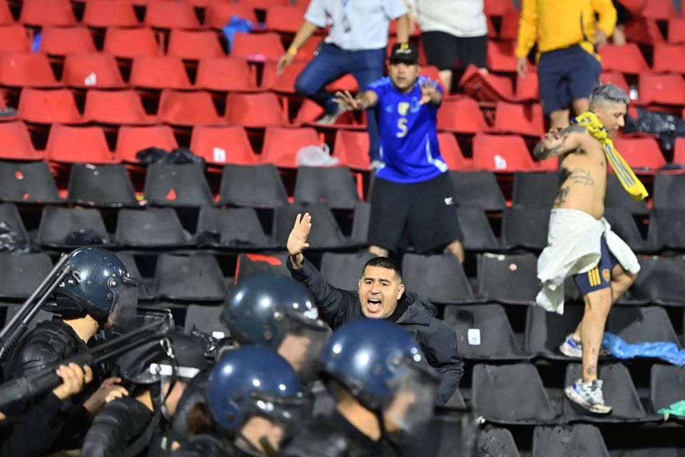 Riquelme tries to stop the riot police officers engaging with Boca Juniors fans.