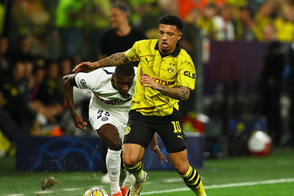 Paris St Germain's Nuno Mendes in action with Borussia Dortmund's Jadon Sancho