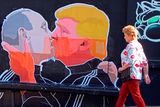 thumbnail: A woman walks past a mural on a restaurant wall depicting US  Presidential hopeful Donald Trump and Russian President Vladimir Putin greeting each other with a kiss in the Lithuanian capital Vilnius. Photo: PETRAS MALUKAS/AFP/Getty Images