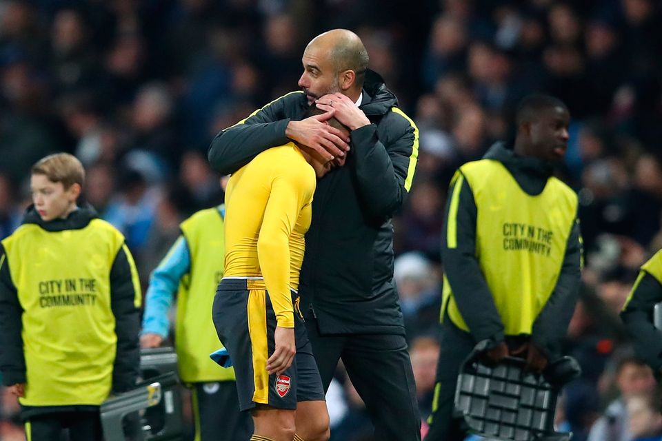 Alexis Sanchez of Arsenal (L) and Josep Guardiola, Manager of Manchester City (R) embrace after the final whistle during the Premier League match between Manchester City and Arsenal at the Etihad Stadium on December 18, 2016 in Manchester, England.  (Photo by Clive Brunskill/Getty Images)
