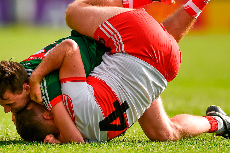 Derry’s Emmett McGuckin and Mayo’s Diarmuid O’Connor tussle at MacHale Park. Photo: Sportsfile