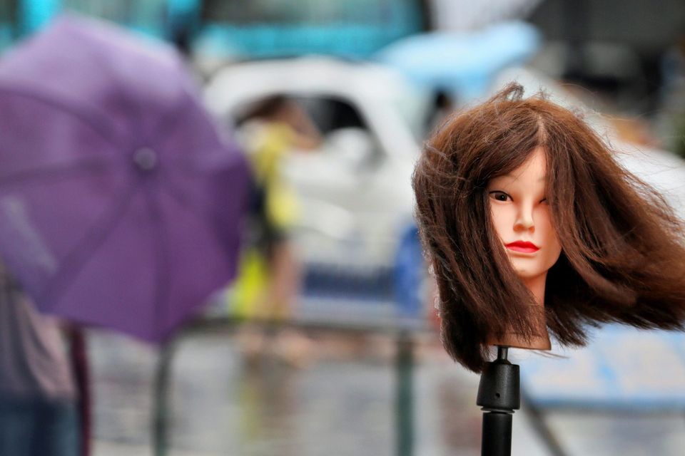 A hairdressing mannequin is seen outside a hair salon amid as Typhoon Matmo hits Nantong, Jiangsu province