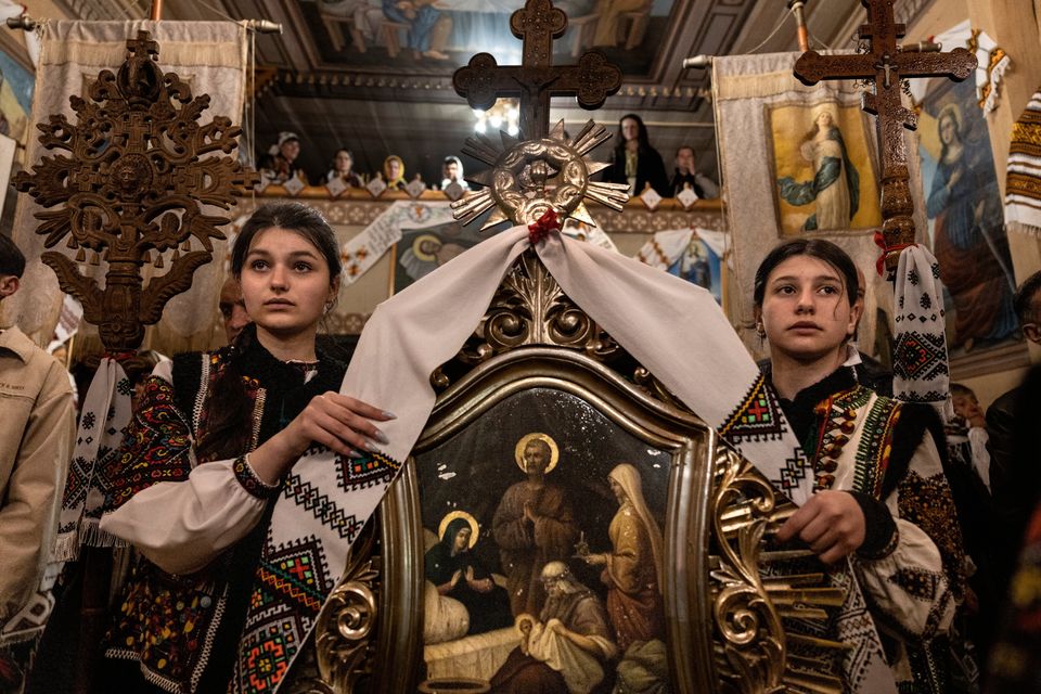 Yulianna Semyan (13) left and Daniella Shkorka (12) take part in an overnight Easter service at the Church of the Nativity of the Theotokos in Kryvorivnia, Ukraine yesterday. Photo: Paula Bronstein /Getty Images