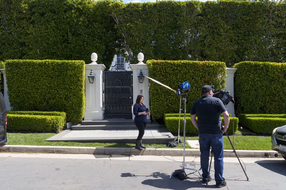 Television crews report live outside a property belonging to Sean ‘Diddy’ Combs (Damian Dovarganes/AP)