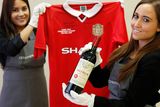 thumbnail: Christie’s staff with a bottle of Petrus 1988 and a Manchester United retro Champions League shirt from 1999. Reuters