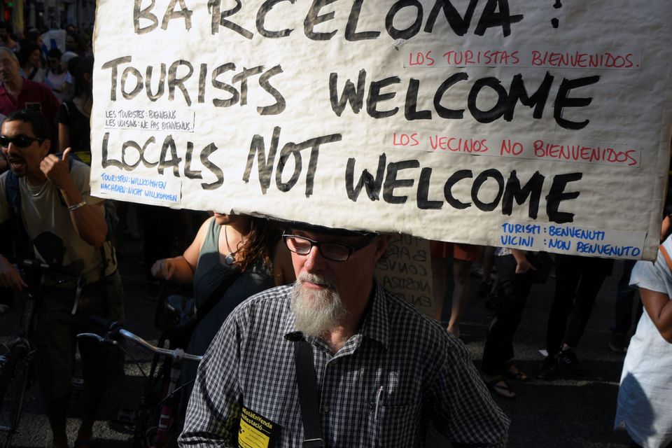 A protesters carry a banner that reads, "Barcelona: Tourist welcome, locals not welcome"  during a demonstration in Barcelona on June 10, 2017 against what they claim is a lack of control by the city's tourism management. Photo: AFP