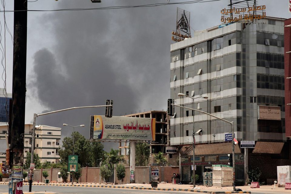 Smoke rises from beyond a business area in Khartoum following aerial bomb attacks