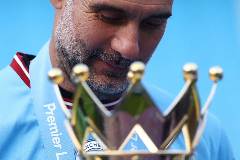 Manchester City manager Pep Guardiola celebrates with the trophy after winning the Premier League