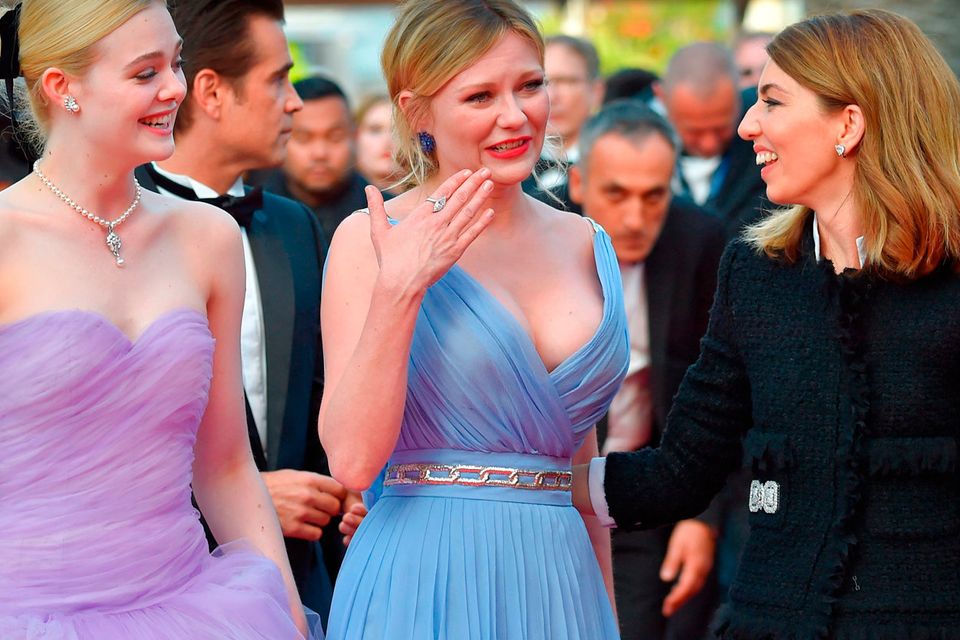 US actress Kirsten Dunst (C) cries as she arrives along with US actress Elle Fanning (L) and US director Sofia Coppola on May 24, 2017 for the screening of the film 'The Beguiled' at the 70th edition of the Cannes Film Festival in Cannes, southern France.  / AFP PHOTO / LOIC VENANCELOIC VENANCE/AFP/Getty Images