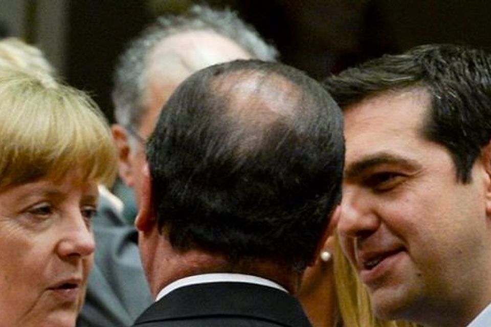 Greek Prime Minister Alexis Tsipras speaks with German Chancellor Angela Merkel (L) and French President Francois Hollande at a euro zone leaders summit in Brussels, Belgium