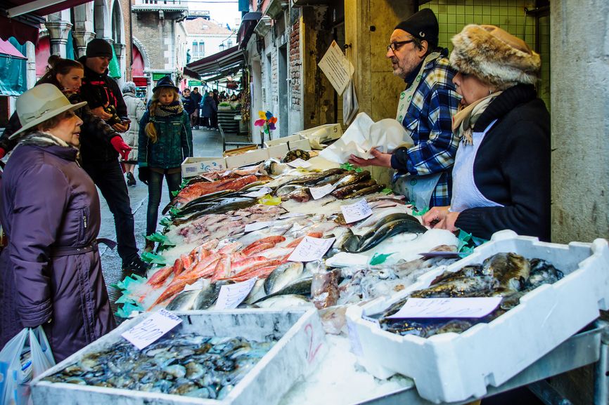 Sellers and shoppers in the Rialto market, in Venice,