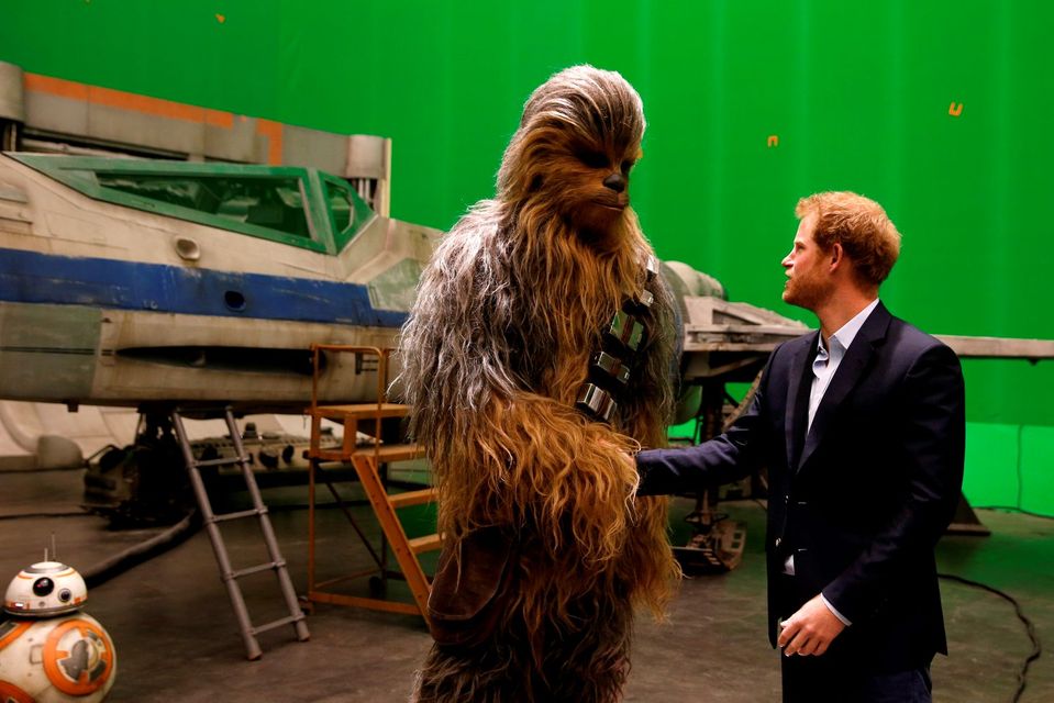 Prince Harry (R) meets Chewbacca during a tour of the Star Wars sets at Pinewood studios on April 19, 2016  in Iver Heath, England. (Photo by Adrian Dennis-WPA Pool/Getty IMages)