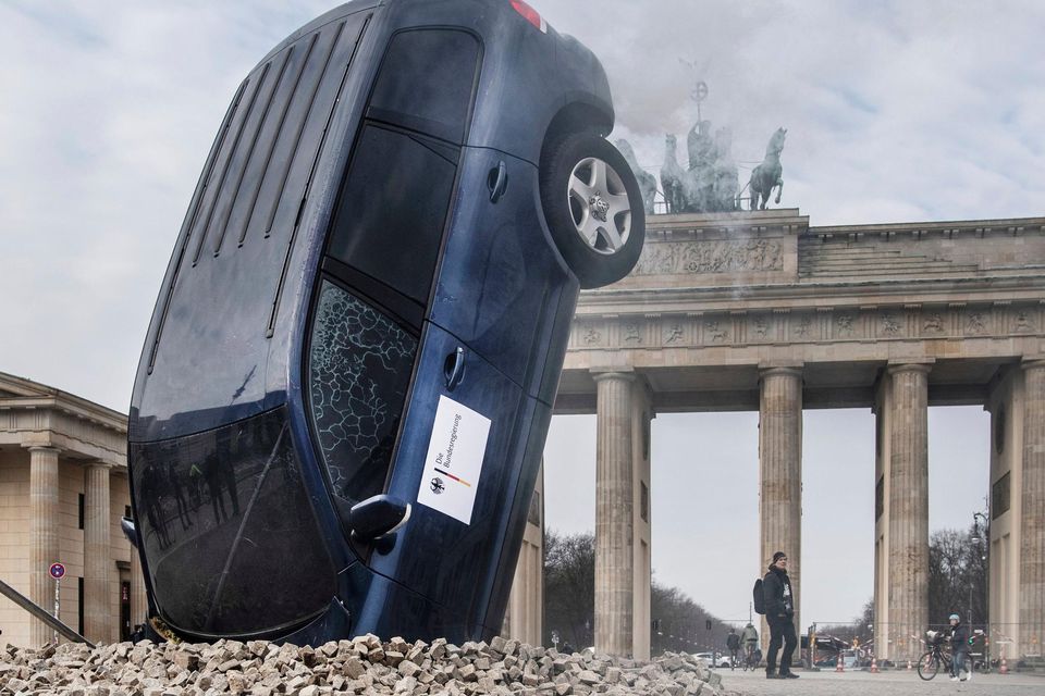 An SUV appears to be stuck in the ground in front of the Brandenburg Gate in Berlin as part of a stunt by Greenpeace activists protesting against the German government's transport policy. Photo: Paul Zinken/AP