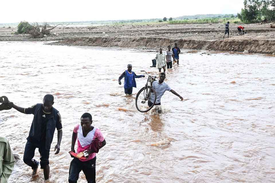 People wade through floodwaters caused by Tropical Cyclone Freddy in Malawi (AP)