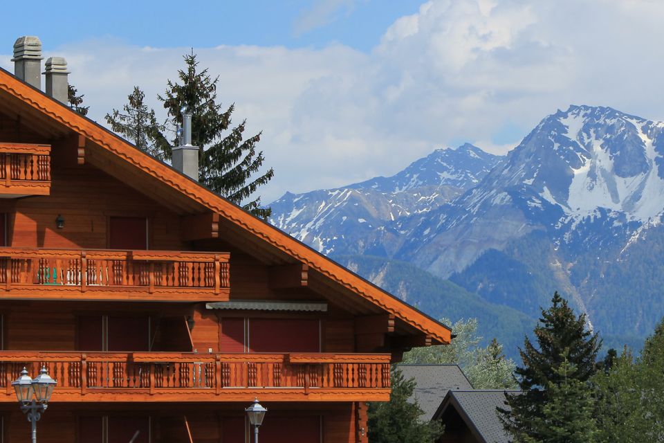 Swiss chalet and Alps mountains in summer at Crans-Montana, Switzerland