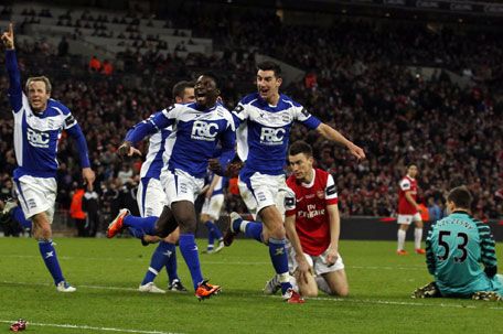 Birmingham players celebrate with Obafemi Martins after he scored  the winning goal against Arsenal yesterday following a mix-up between goalkeeper Wojciech Szczesny (right) and Laurent Koscielny. Photo: Reuters