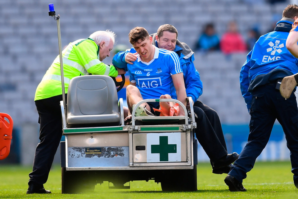 Dublin captain Chris Crummey has to be taken off after suffering an ankle injury