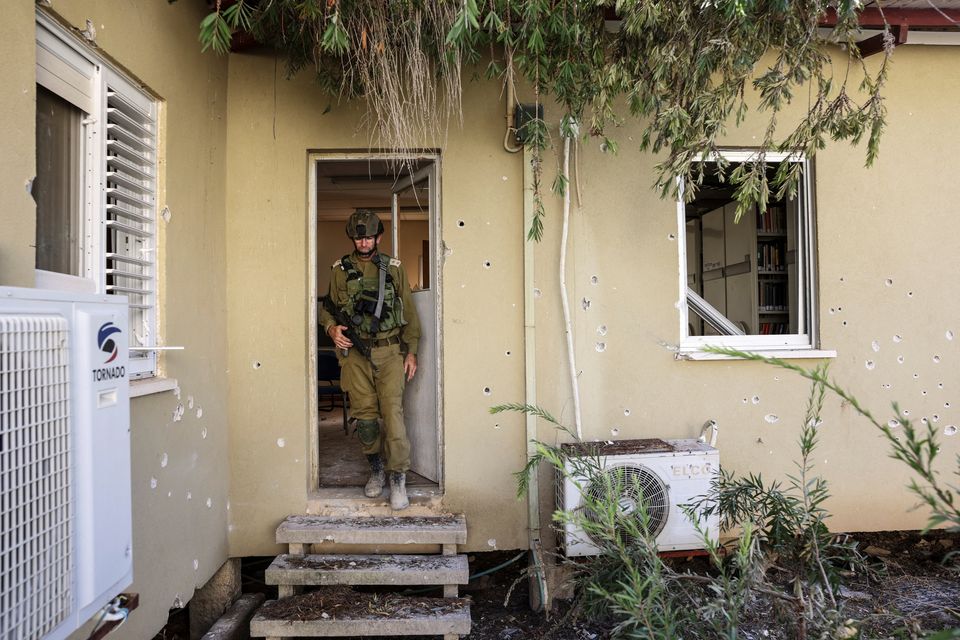 An Israeli soldier leaves a family home with walls littered with bullet holes, following a deadly infiltration by Hamas gunmen from the Gaza Strip, in Kibbutz Beeri in southern Israel October 17, 2023. REUTERS/Ronen Zvulun