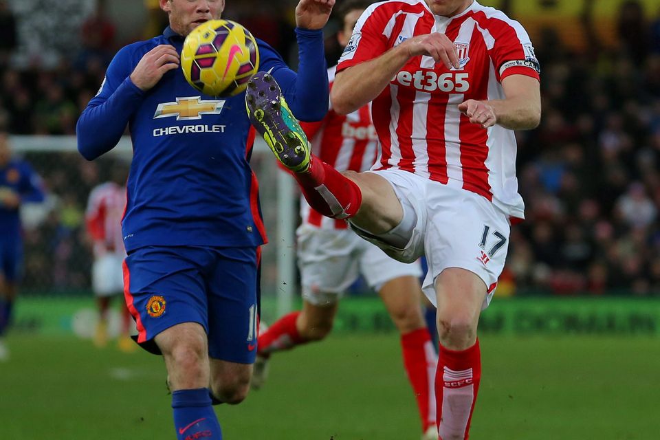 Stoke City's Ryan Shawcross clears the ball ahead of Manchester United's Wayne Rooney