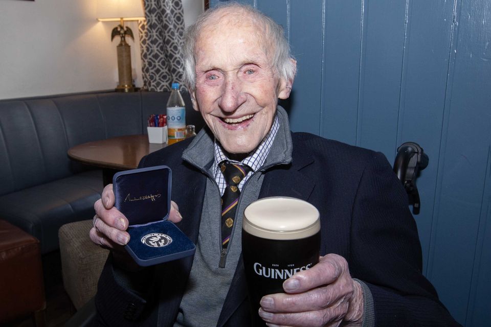 Michael with his medal from President Michael D Higgin and a pint of Guinness in Hester's, Golden Eagle, Castlerea.
Photo Brian Farrell