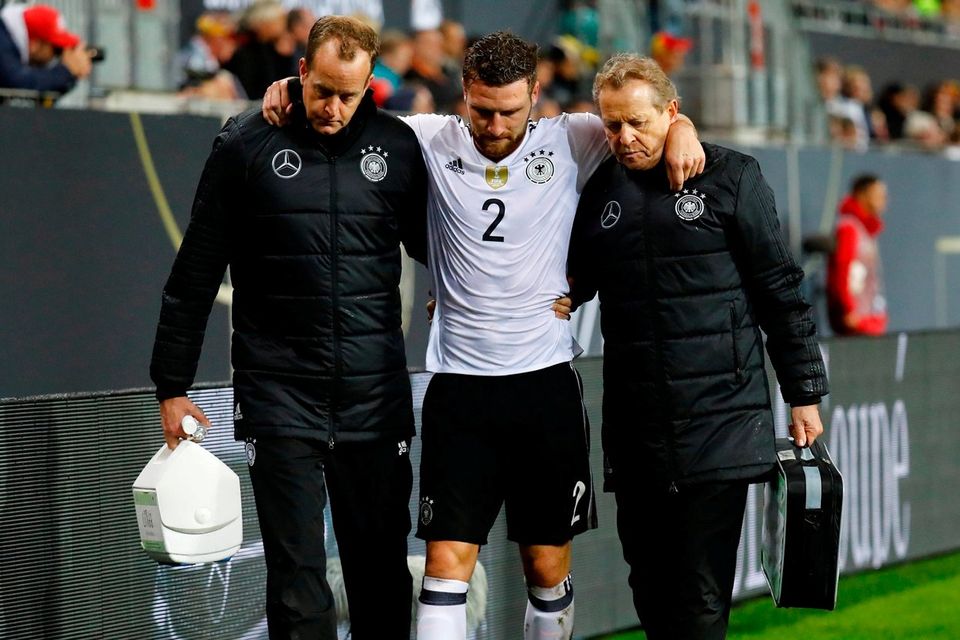 Germany’s Shkodran Mustafi receives medical attention after sustaining an injury last night.   REUTERS/Kai Pfaffenbach