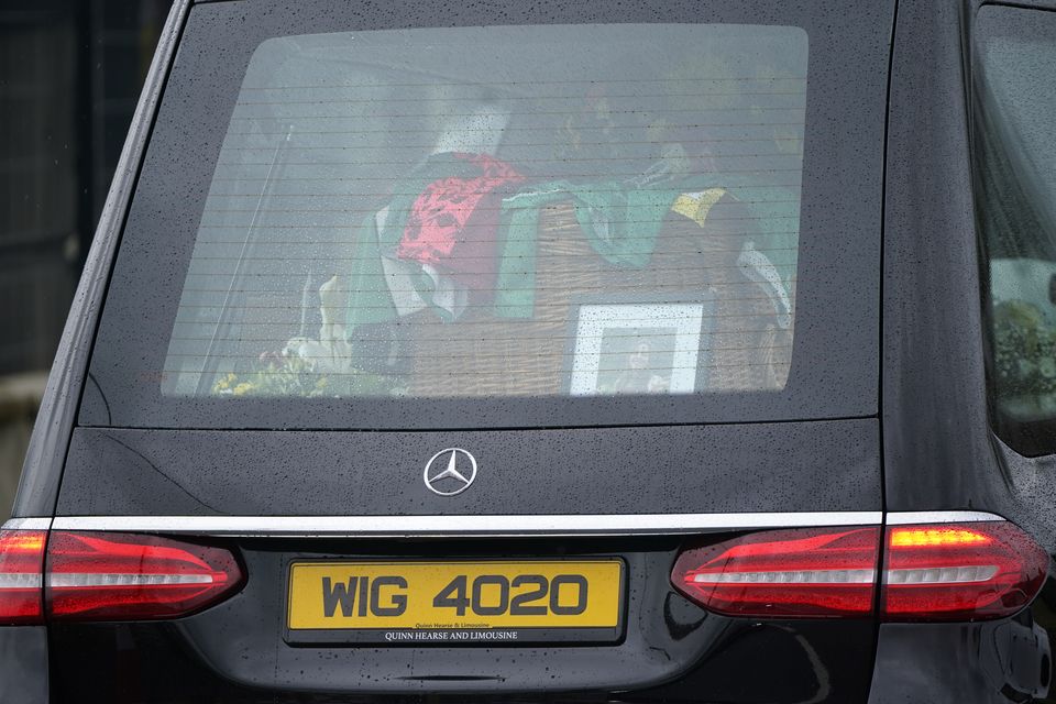 Flowers, photographs and sports tops were placed with the coffins (Niall Carson/PA)