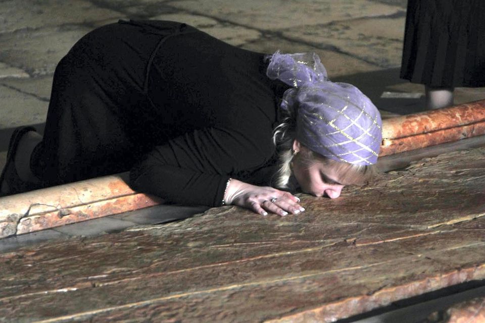 A lady kissing The Stone of Anointing in the Church of Holy Sepulchre in The Old City of Jerusalem. Pic: Jim Campbell