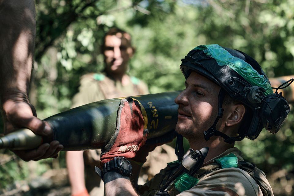 A Ukrainian soldier carries a rocket for a Grad multiple rocket launcher to fire towards Russian positions in the frontline near Bakhmut on May 17. Photo: AP
