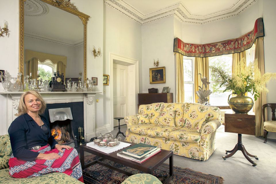 Aisling Law in her drawing room, which is decorated in soft grey and yellow. The mother and child depicted in the painting are Robert’s great grandmother and his grandfather. The fabric used as a pelmet on the curtains is from Tibet, and was given to Aisling by her father when her son, Emile, was born.