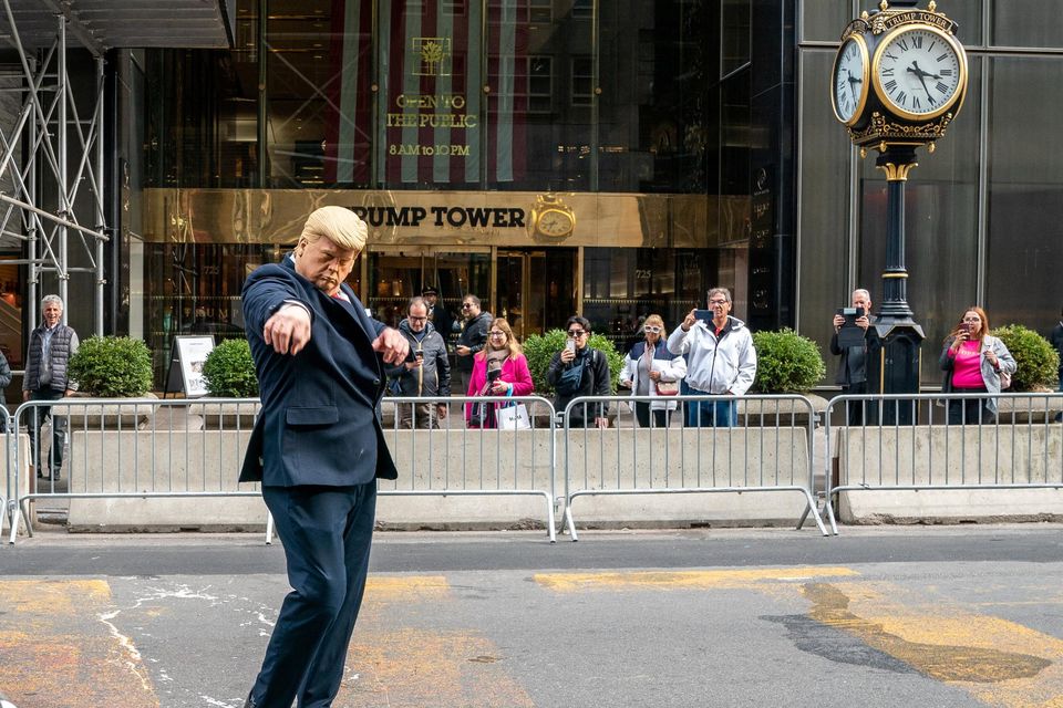 A performer wearing a mask depicting former president Donald Trump directs traffic outside of Trump Tower in New York. Photo: David 'Dee' Delgado/Reuters