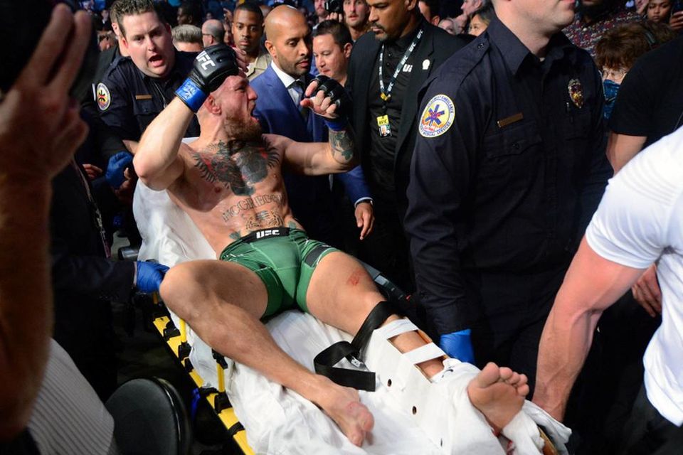 Conor McGregor is carried off on a stretcher following an injury in his loss against Dustin Poirier