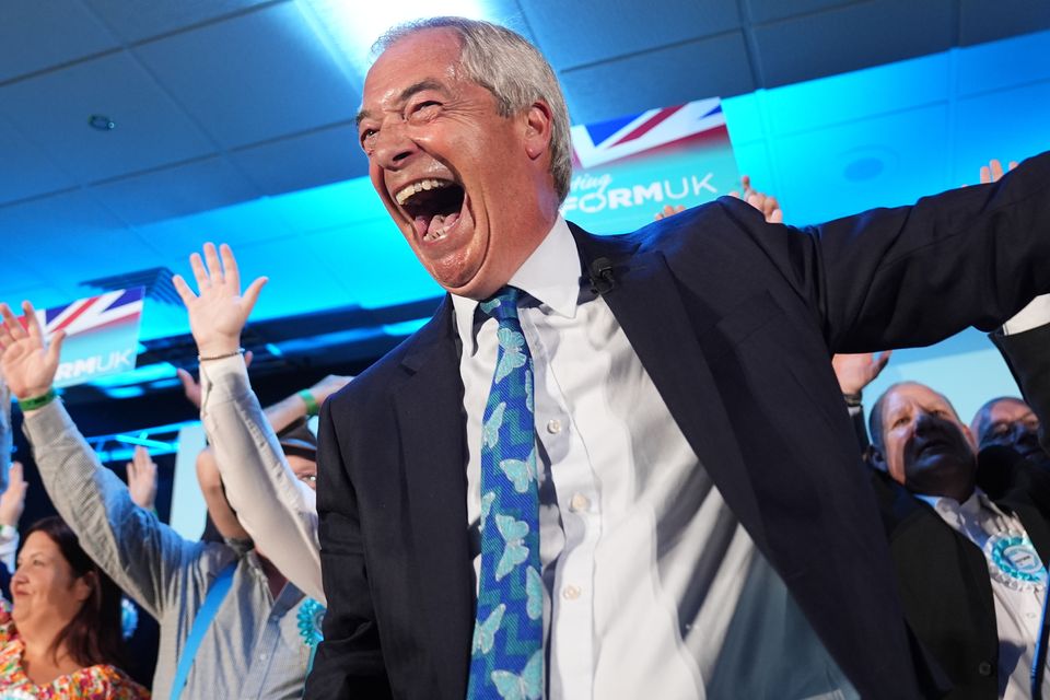 Reform UK party leader Nigel Farage with his party’s candidates onstage during a campaign event at Stafford Showground (Jacob King/PA)
