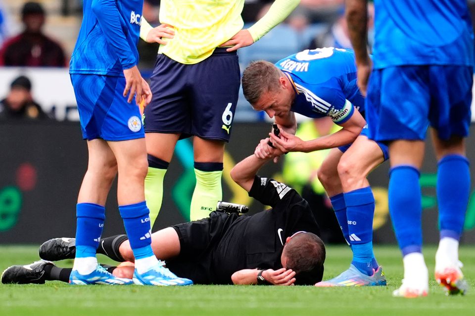 Referee David Webb appears injured after a collision with Leicester City's Jordan Ayew (right) as Jamie Vardy blows the referee whistle to stop play during the Premier League match at the King Power Stadium, Leicester
