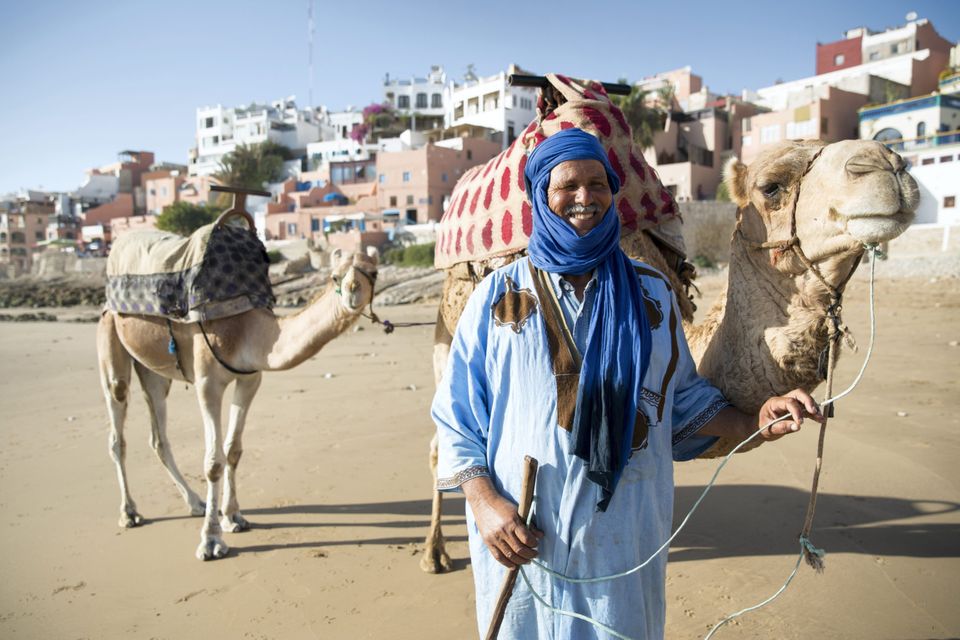 Man with camel on beach, Taghazout, Morocco