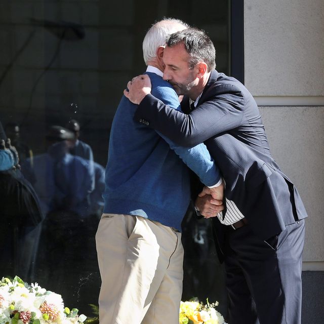 Berkeley Mayor Tom Bates (L) hugs Philip Grant, Consul General of Ireland to the Western United States, following a wreath-laying ceremony at the scene of a 4th-story apartment building balcony collapse in Berkeley