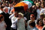 thumbnail: Kevin McGuigan's widow, Dolores, is comforted as the coffin of the former IRA man is carried from St Matthew's Church in east Belfast following his funeral this week Photo: PA