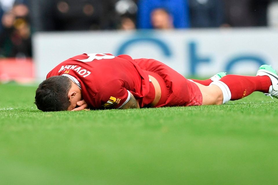 Liverpool's Croatian defender Dejan Lovren lies injured after a tangle with  Manchester United's Belgian striker Romelu Lukaku yesterday