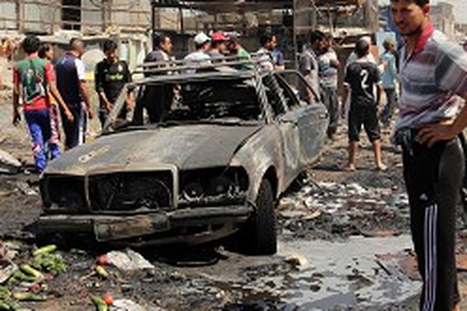 People inspect the site of a car bomb attack at a vegetable market in the Jamilah area of Baghdad on Wednesday (AP)