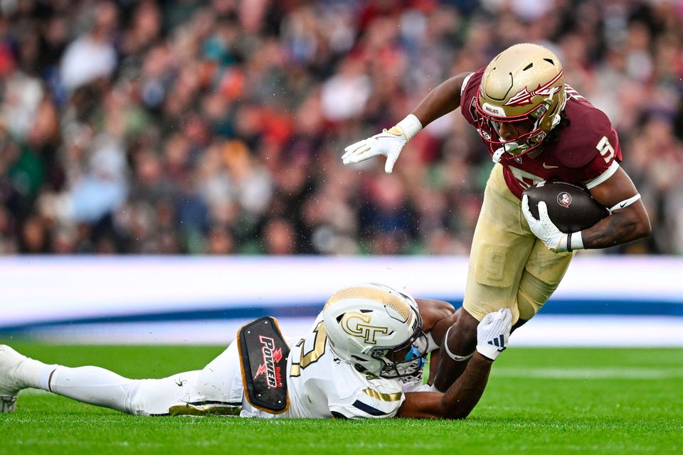 24 August 2024; Florida State Seminoles running back Lawrance Toafili is tackled by Georgia Tech Yellow Jackets defensive back Ahmari Harvey during the 2024 Aer Lingus College Football Classic match between Florida State and Georgia Tech at Aviva Stadium in Dublin. Photo by Brendan Moran/Sportsfile 